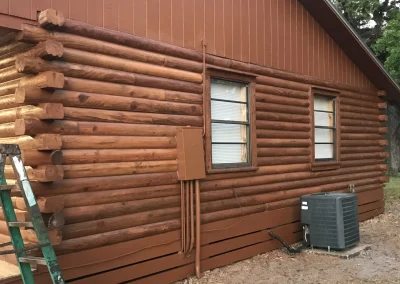 Stained log cabin with new windows, power, and air conditioning