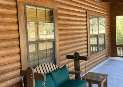log cabin wall with new windows, deck, and roof