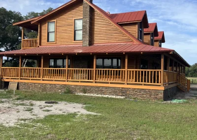 Painted log cabin with red metal roof