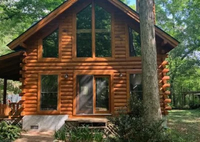Stained cabin in the woods with new windows